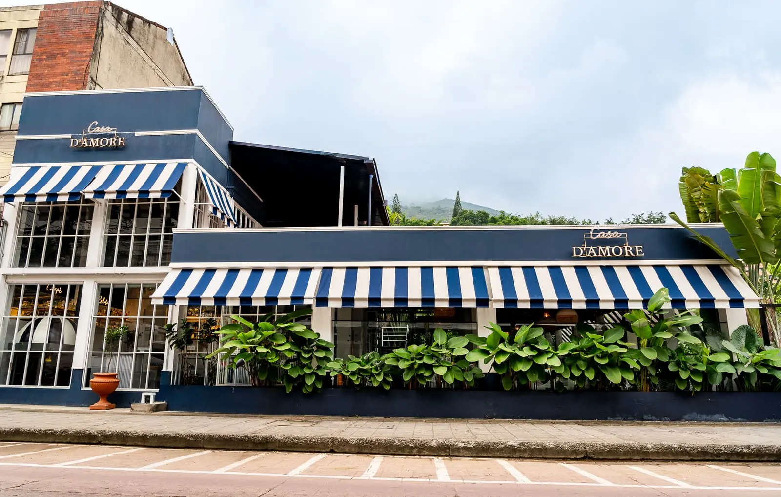 Casa D'Amore — fachada del restaurante con toldos azules y blancos en Medellín